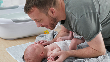 Bub wearing Huggies nappy with dad and Midwife Cath